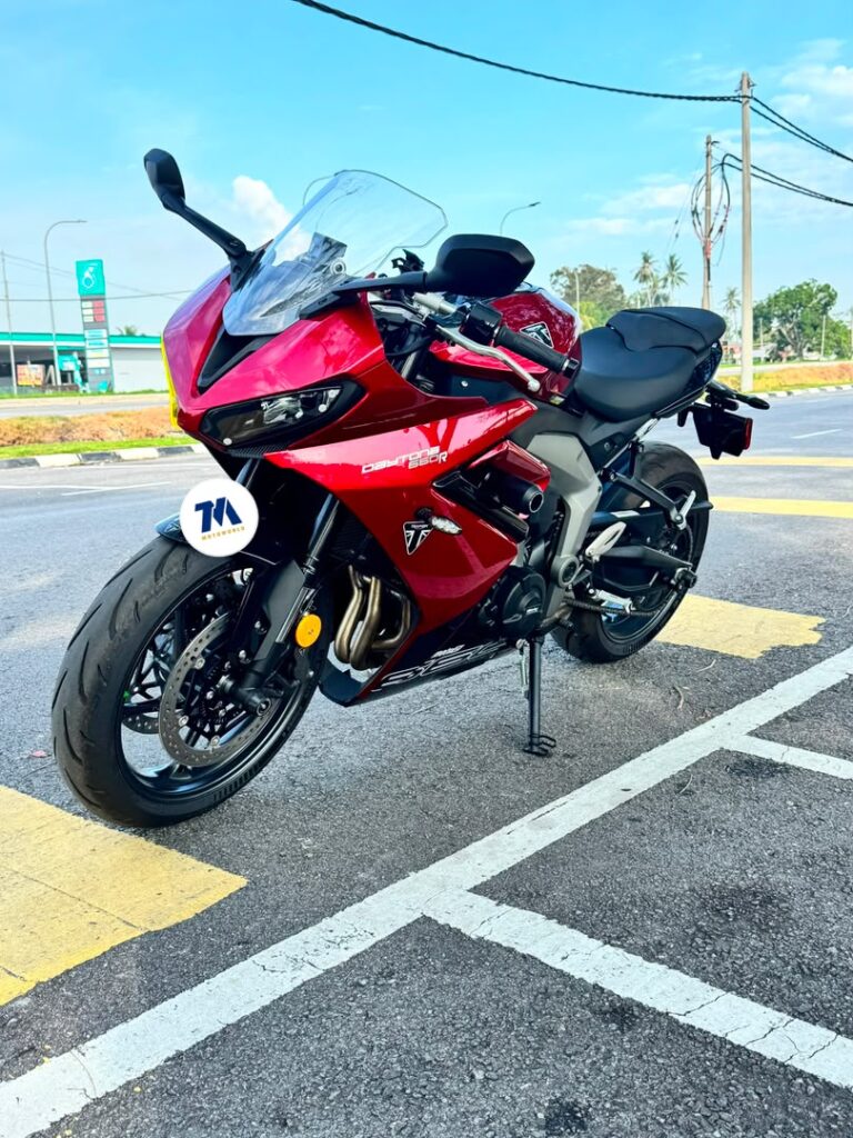 Front view of a red motorcycle with headlight, handlebars, and fairing visible