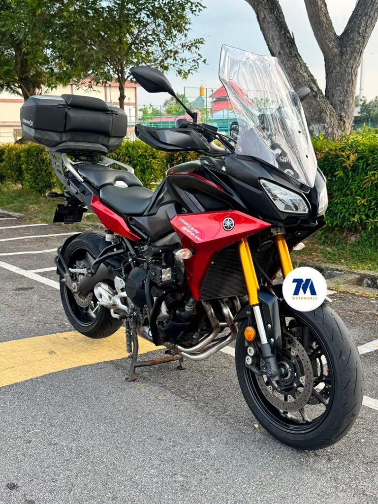 Front view of a red and black motorcycle with tall windscreen.