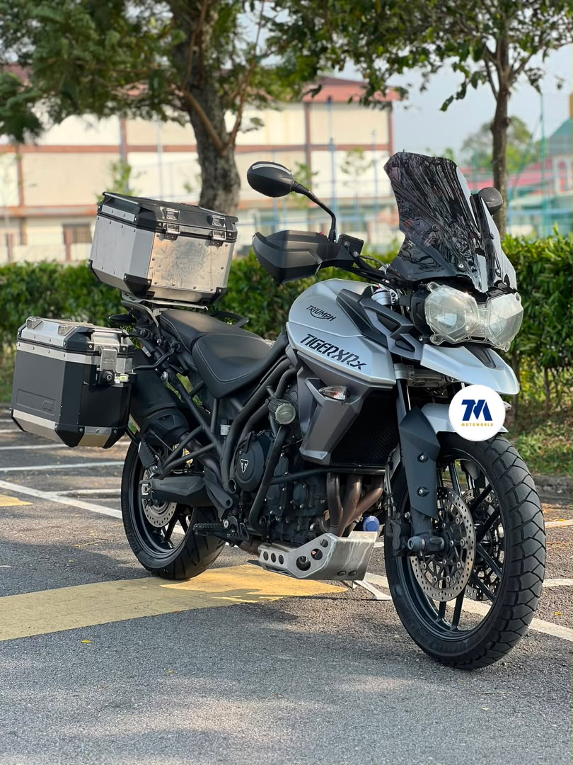 Front 3/4 view of a Triumph Tiger XRx motorcycle with panniers.