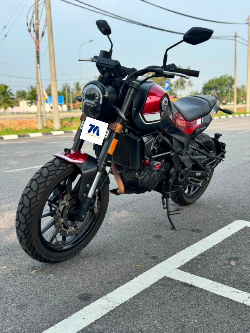 Front view of the red and black used motorcycle in a parking area.