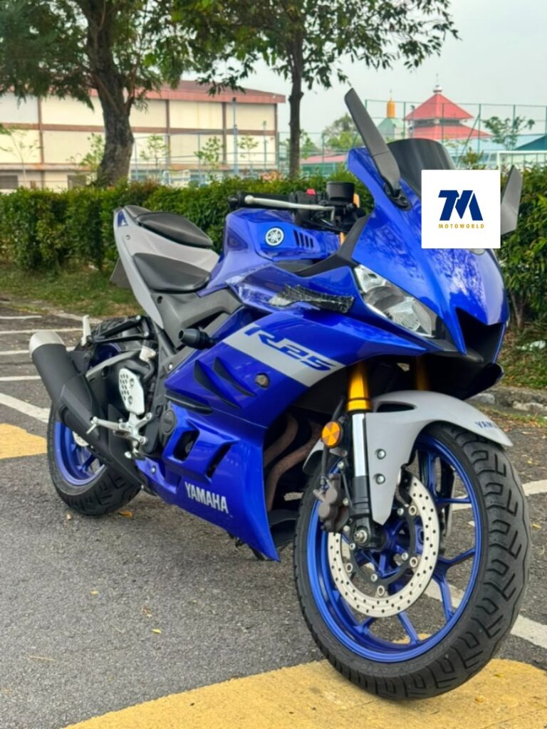 Front-3/4 view of a blue motorcycle, headlight and handlebars visible
