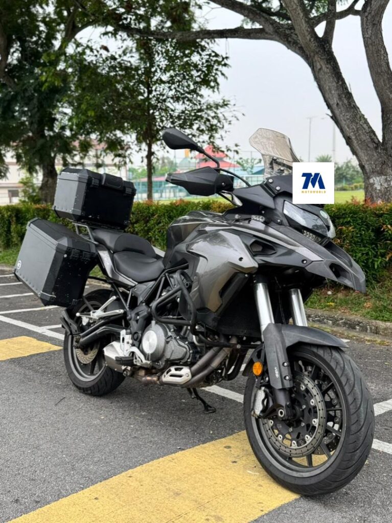 Front-3/4 view of a motorcycle with side boxes on a road