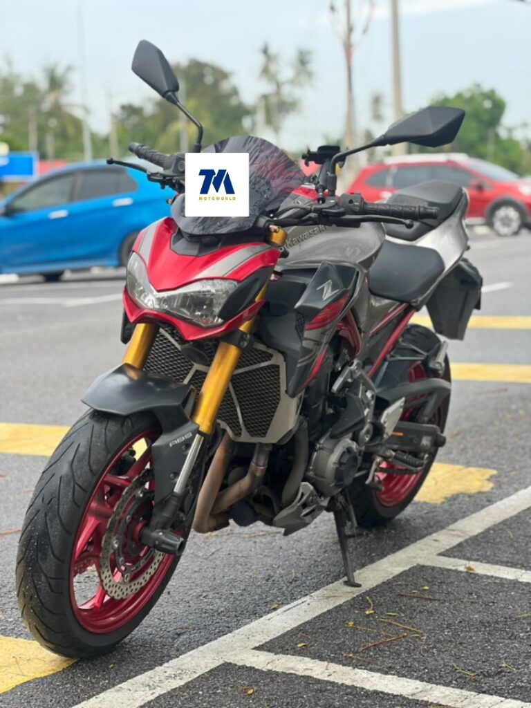Kawasaki Z900 facing the camera with red and black fairing