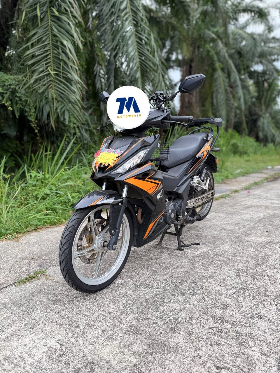 front view of a black and orange Honda RS150R motorcycle