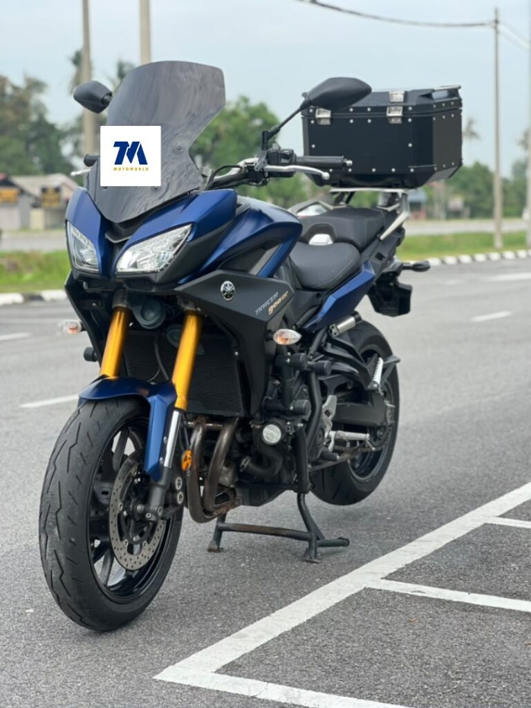 front view of blue motorcycle with black panniers