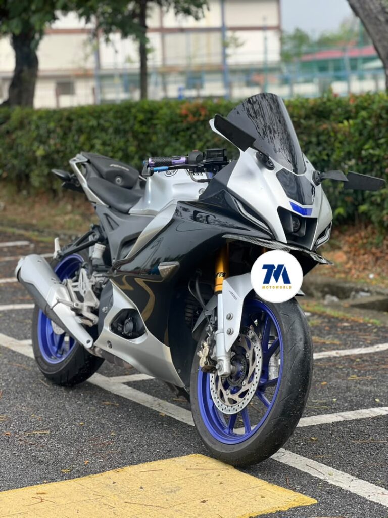 Front view of a Yamaha R15M motorcycle with blue wheels and a sporty design