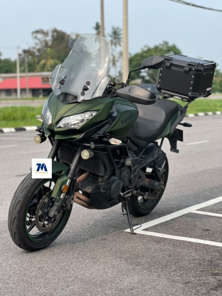 Front view of a green Kawasaki Versys 650 with windshield and panniers